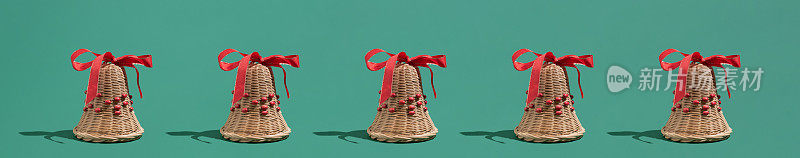 Festive natural décor Christmas idea with wooden bells and red ribbons on green background. Minimal New Year winter season concept.